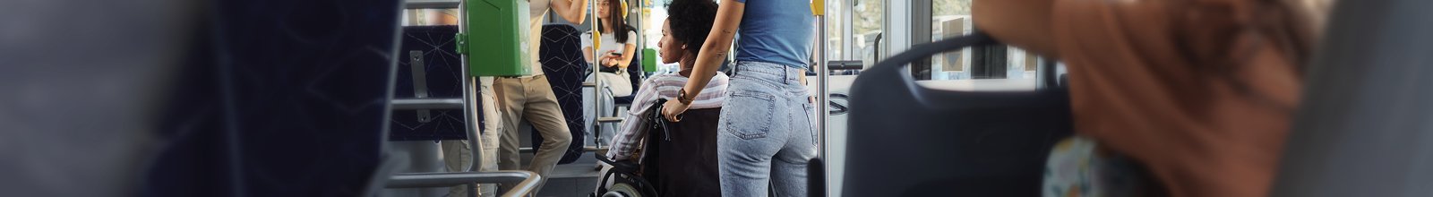 Person in wheelchair on bus being pushed