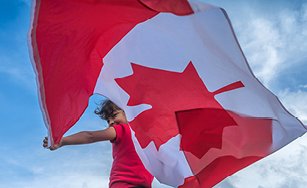 Image of a person waving a Canadian flag