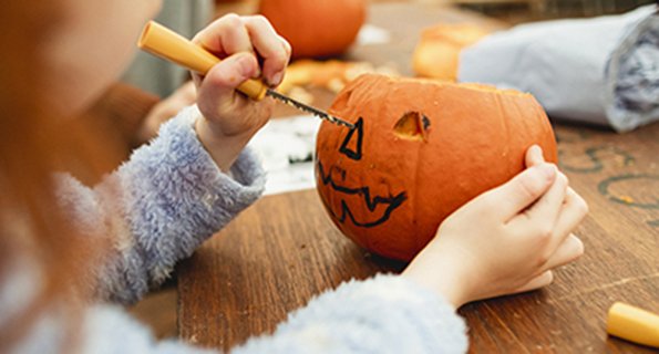 Image of child carving a pumpkin