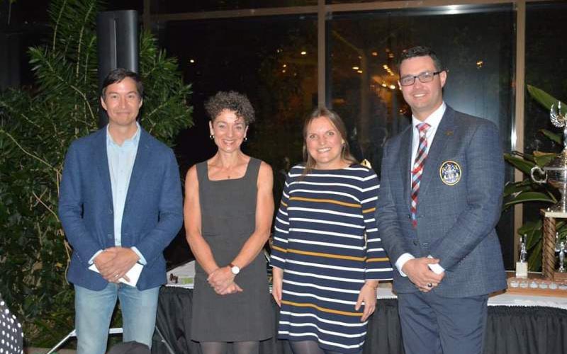 Four people standing up to present a donation.