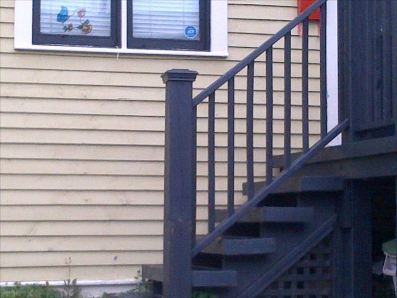 Proper railing construction and stained pressure treated lumber on exterior of Heritage house