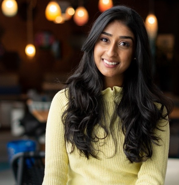 Image of Radhika Verma, smiling at camera, against a blurred background