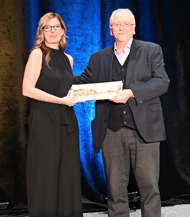 Councillor Jill Bruce and Stephen Jewczyk standing on staging holding the award plate