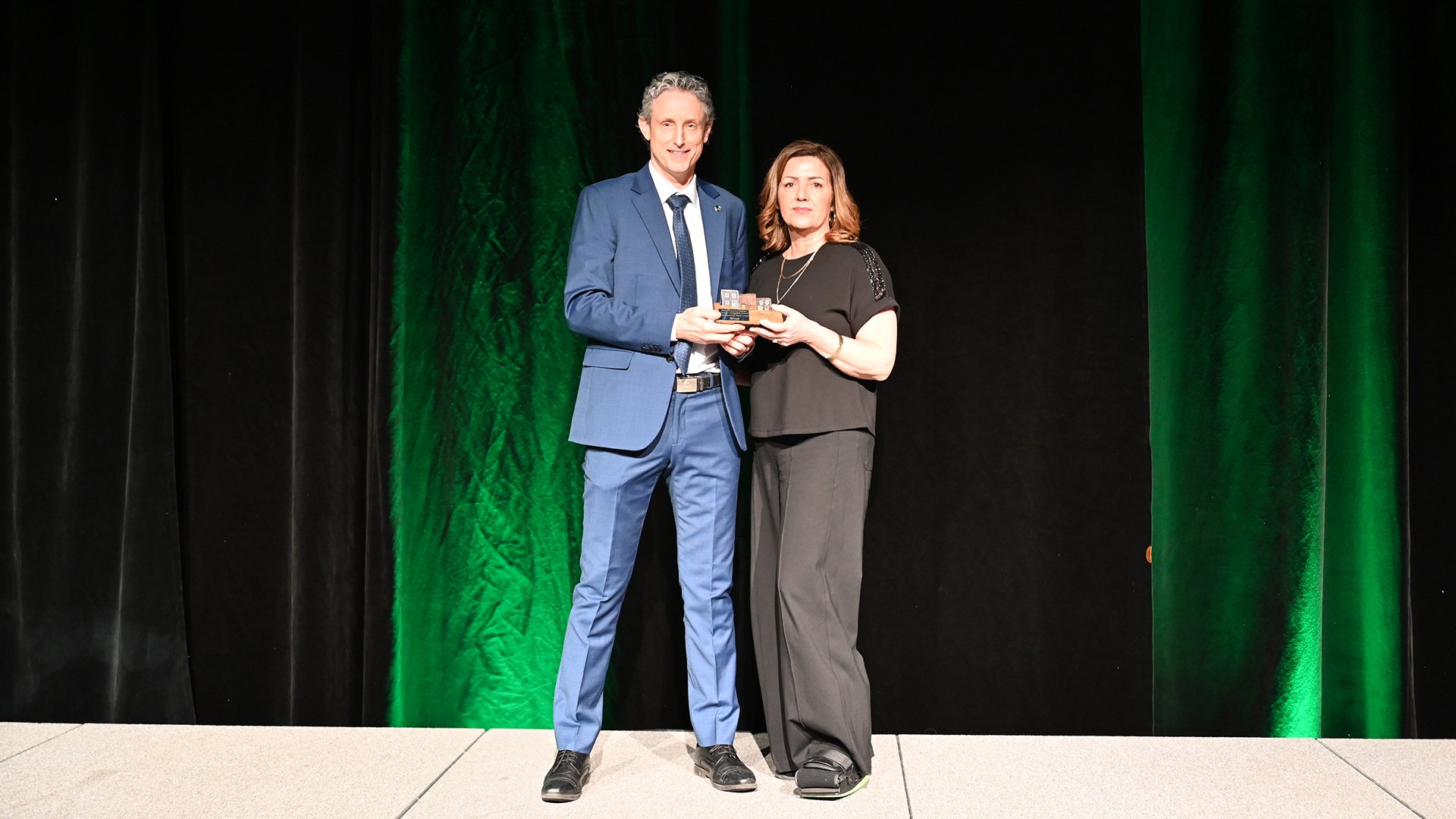 Councillor Tom Davis presents the Corporate Climate Change Leadership Award to Dana Locke from Amerispec NL.