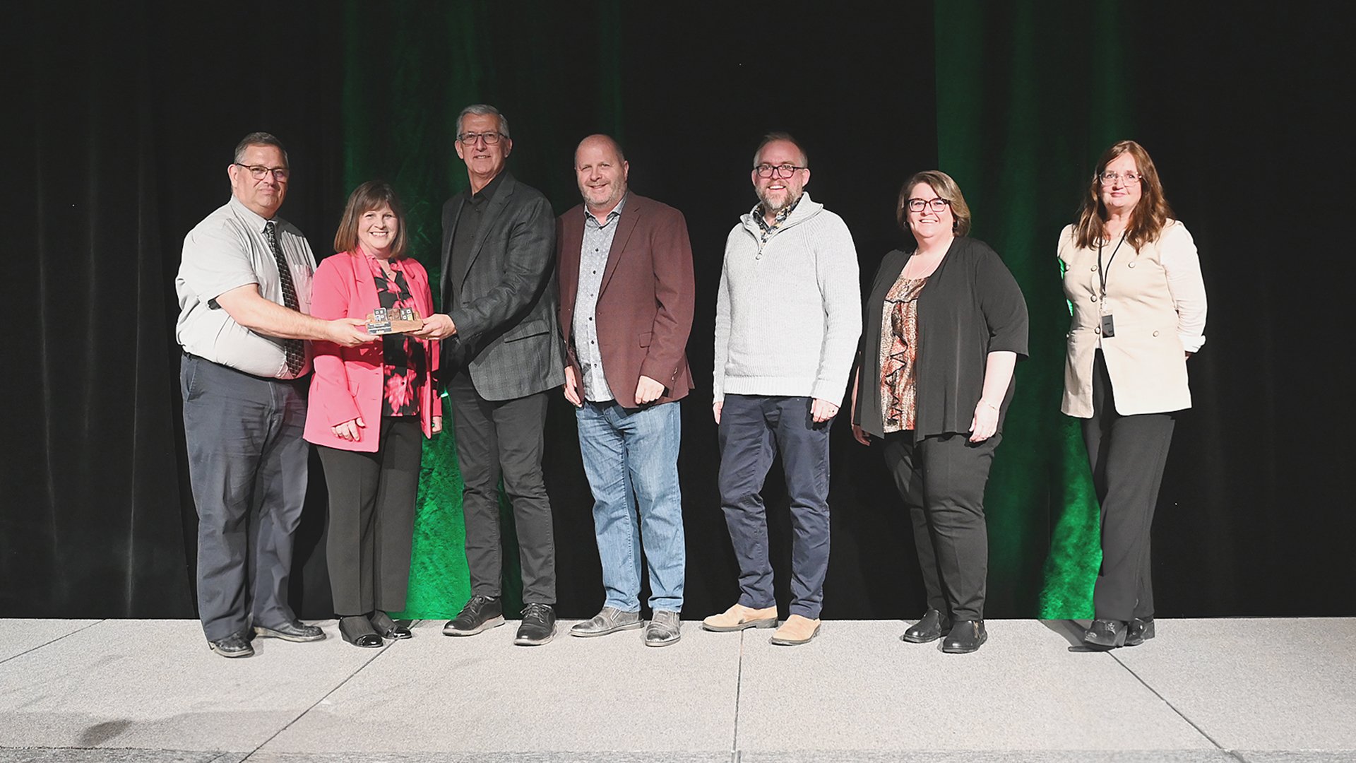 Councillor Ron Ellsworth, left, presents the Innovative Housing Design Award to a group from The Gathering Place.
