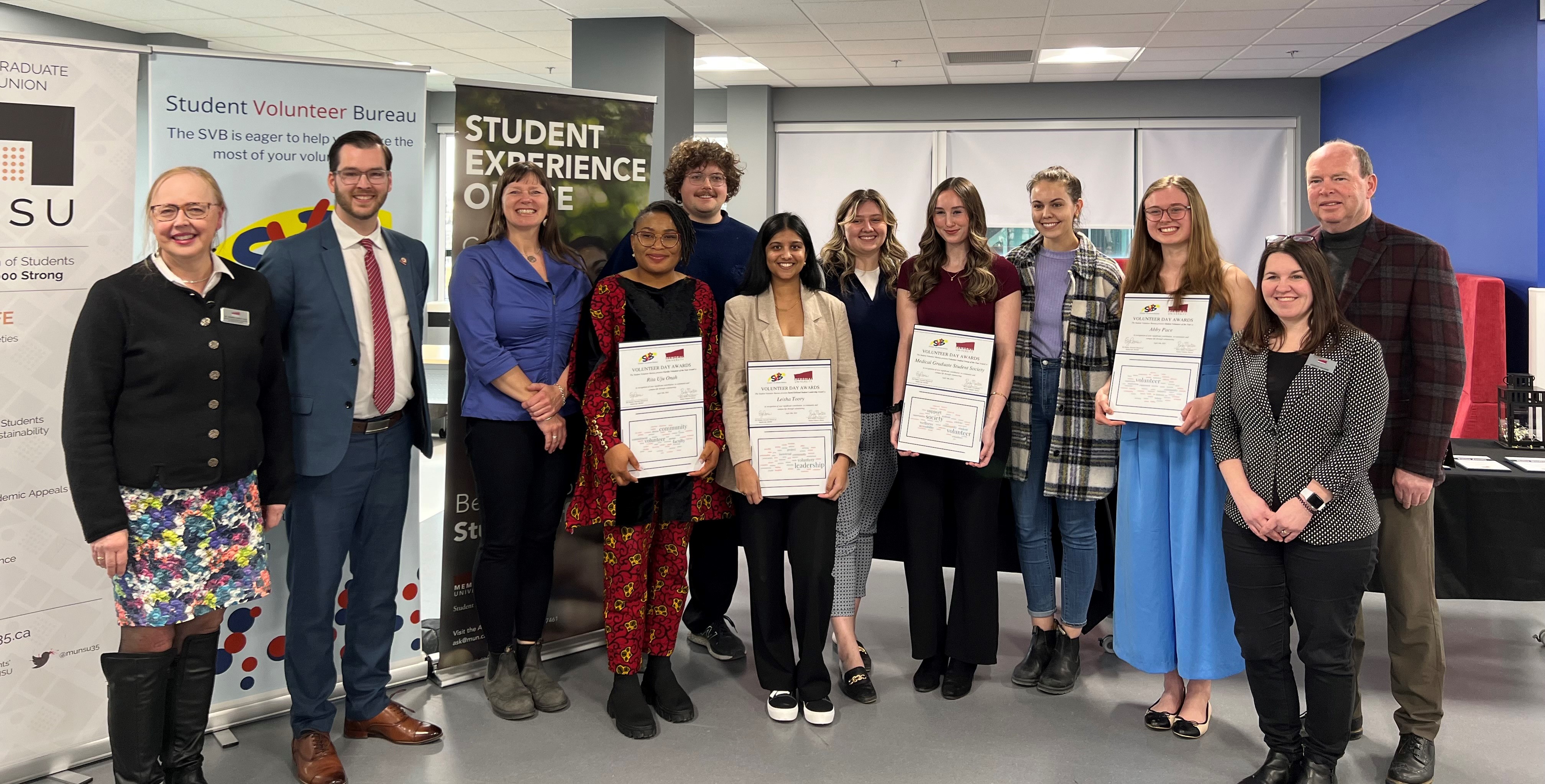 group shot of individuals, some holding awards