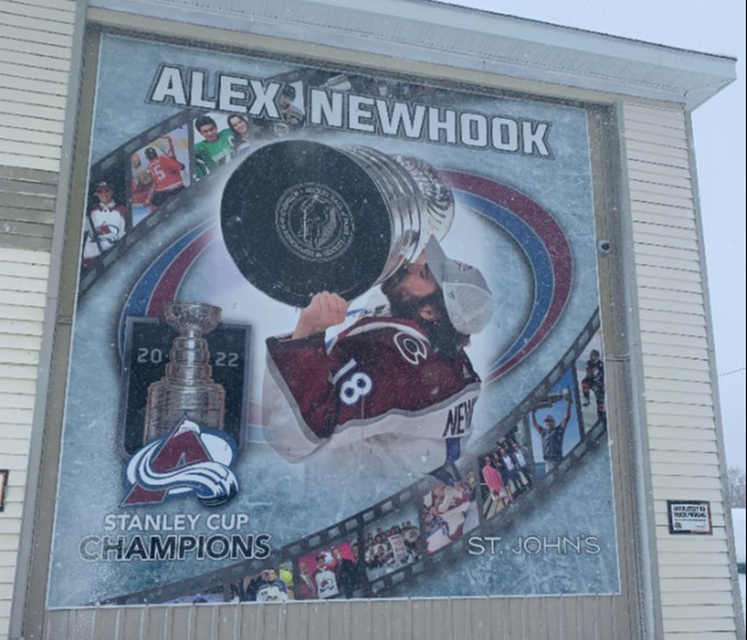 mural depicting Alex Newhook kissing the Stanley Cup with pictures of Alex as a child playing hockey in film strip along bottom