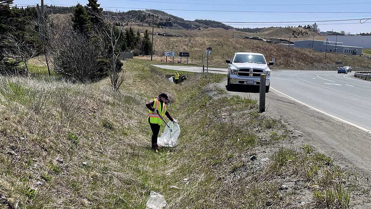 Litter crew picking up litter on East White Hills Road, white truck parked on side of the road