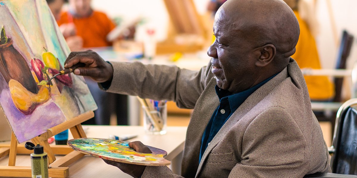 Person painting a canvas of fruit