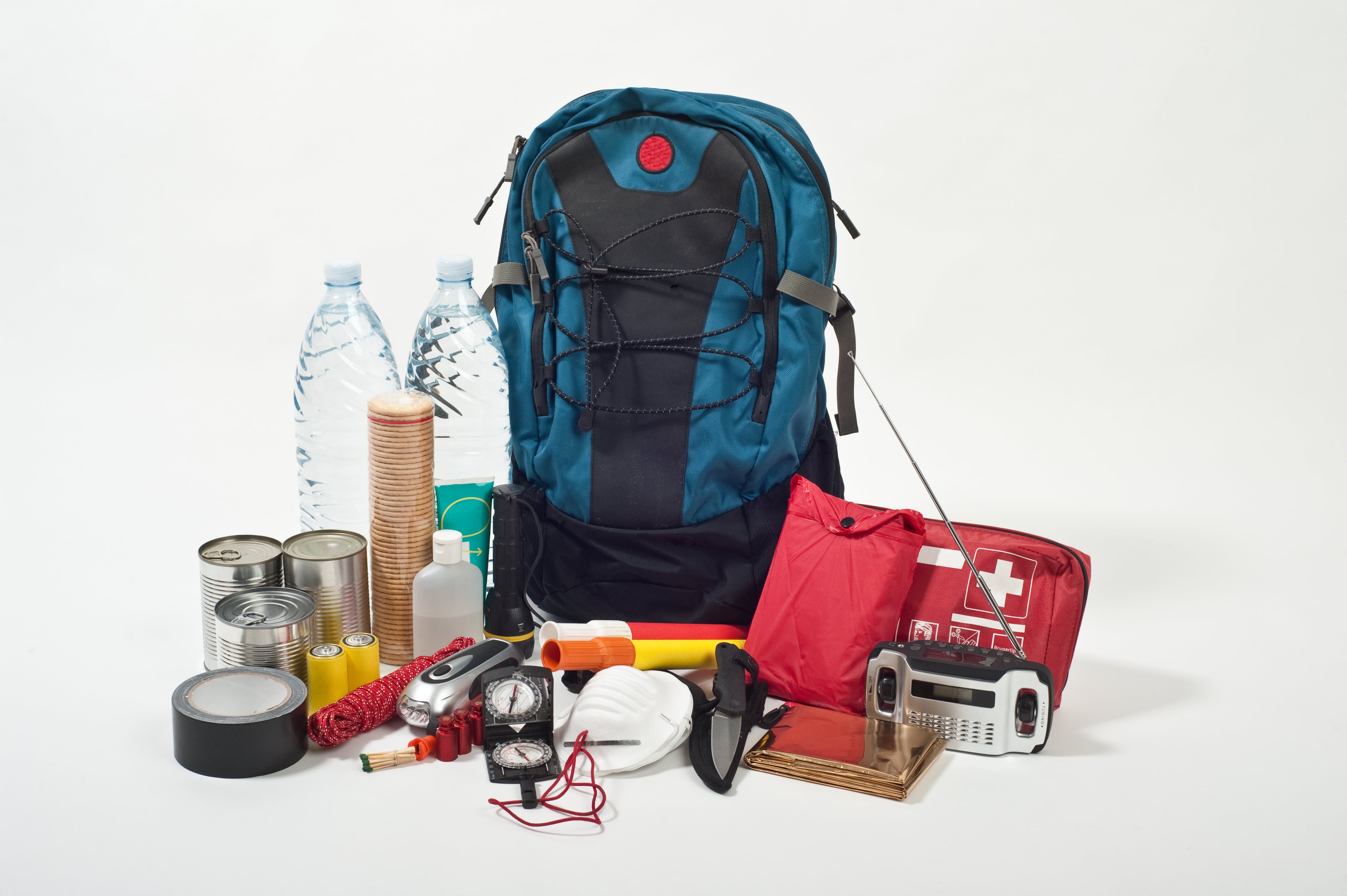 image of backpack with the items of an emergency kit such as water, flashlights and a battery-operated radio