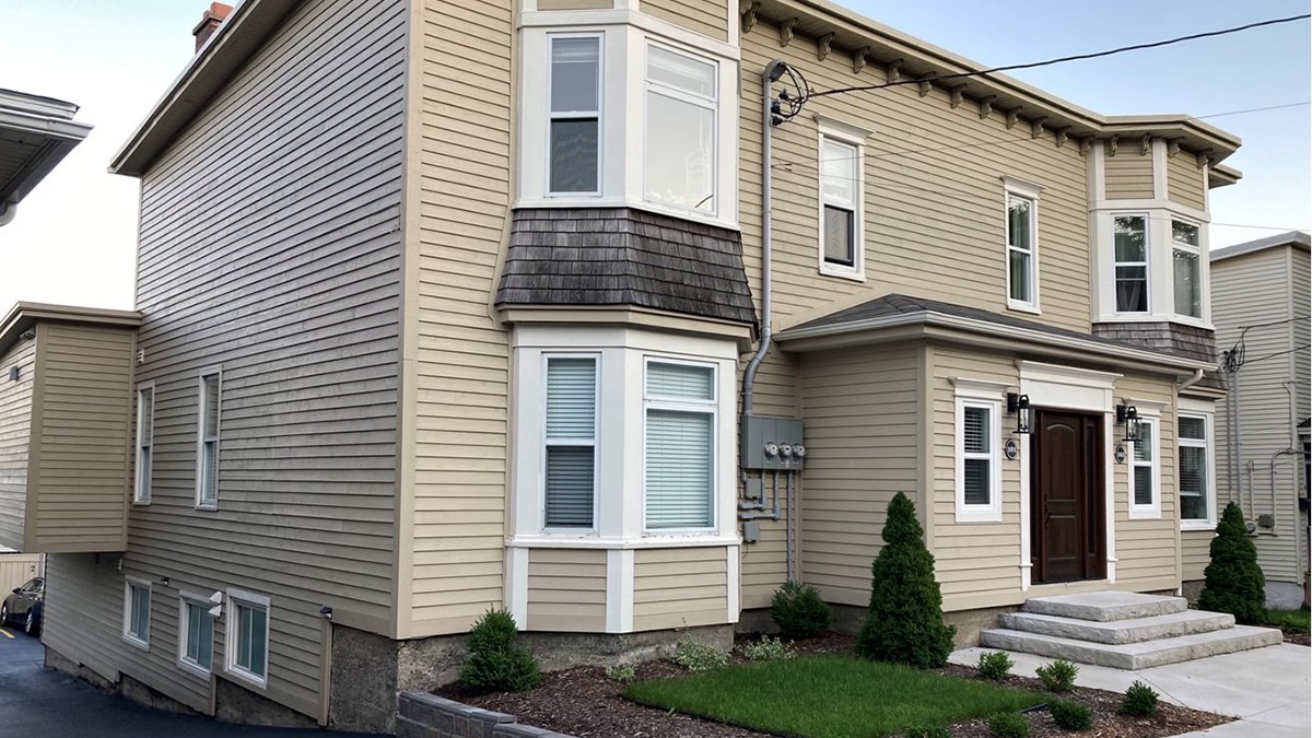 A house in a heritage are with beige siding and white trim.