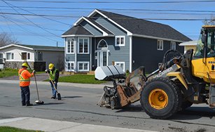 Image of a truck and workers on a street doing construction work