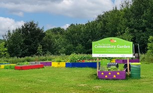 Background image of a community garden with white text "Gardeners Gathering Tuesday, May 27 from 6 to 8 p.m. Paul Reynolds Community Centre Frances Lambe Room" with the Food First NL logo and the City logo.