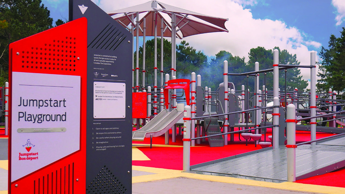 playground structure in the background and sign "Jumpstart Playground" in the foreground