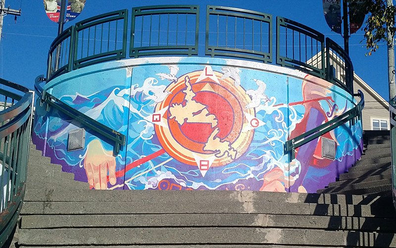 Mural at the landing of stairs between George Street and Duckworth Street. The mural depicts a map of Newfoundland and Labrador on the face of a compass dial.