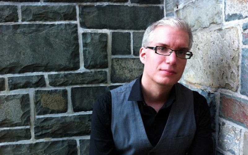 Photo of Ian Foster stood in front of a rock brick wall