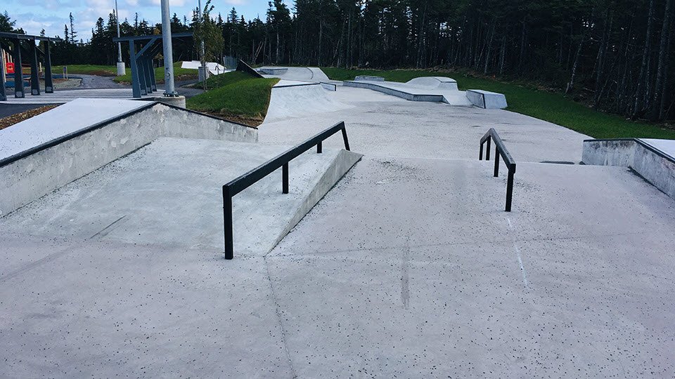concrete slopes of skate park with metal rails