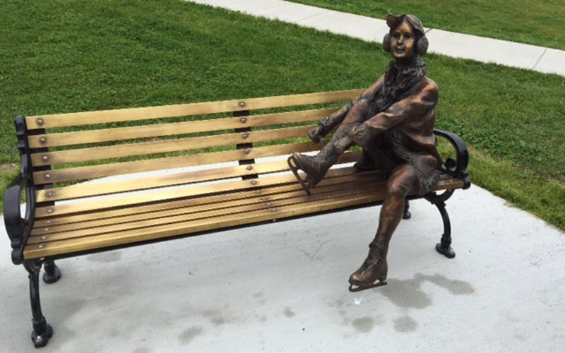 The Skater Sculpture at Bannerman Park. A sculpture of a girl sitting on a park bench tying her skates