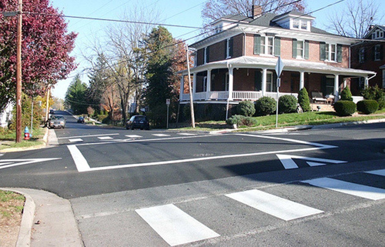 A raised asphalt intersection where the square of asphalt in the middle of the intersection is raised to slow vehicles