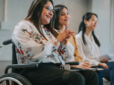 a person in a wheelchair with two other people attending an event