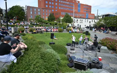 Music @ Harbourside Park event with people sitting and watching artist
