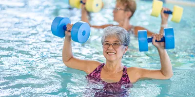 women using water weights in a pool